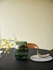 23848-en-silent-vase-20-dark-green-midst-table-160-black-fiber-armchair-refine-leather-cognac-muuto-org.webp